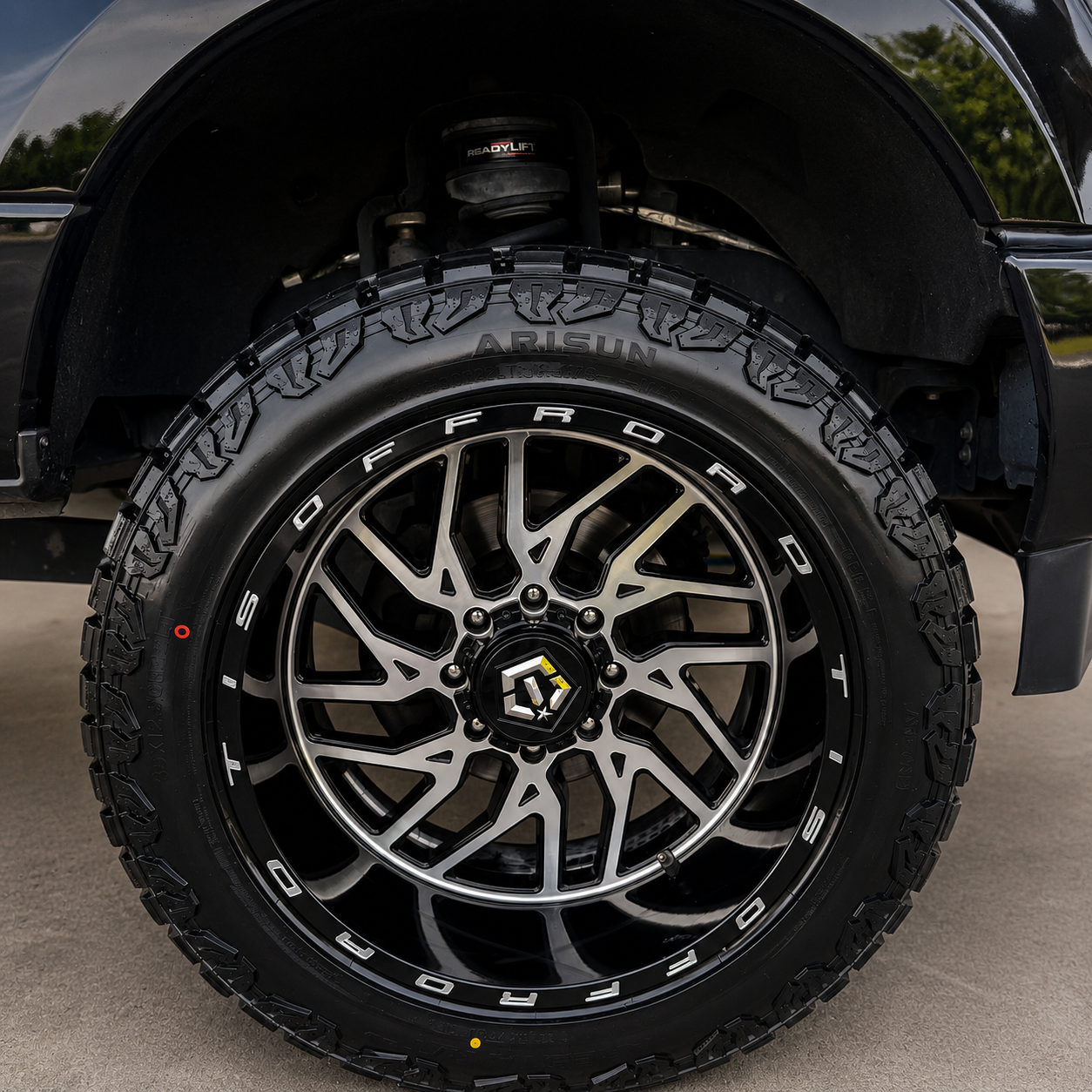 Machined black off-road wheel with a freshly dressed all-terrain tire